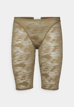 Shorts in pizzo di un verde oliva chiaro con un motivo floreale. Presentano un design aderente e una texture liscia, che termina appena sopra il ginocchio.