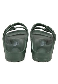 Sandales vertes en moulage avec deux sangles réglables, texture lisse, semelle intérieure ergonomique et motif de grip sur la semelle extérieure.