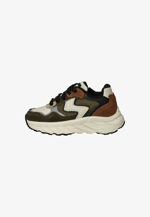 Sneaker met een mix van beige, bruin en zwarte materialen, met mesh- en suède-texturen, een chunky witte zool en zwarte veters.