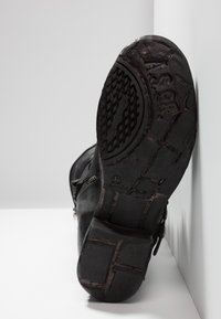 Czarne skórzane botki do kostki z teksturowaną gumową podeszwą. Posiadają boczny zamek błyskawiczny i elementy w kolorze srebrnym, rozmiar oznaczony jako 37.