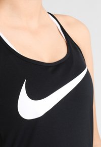 Sort aktiv tanktop med et hvidt Nike swoosh-logo, lavet af glat stof, med rund halsudskæring og tynde stropper.