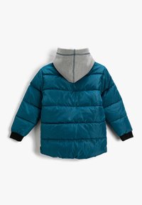 Teal pufferjack met een grijze hoodie, met horizontaal gestikte panelen, zwarte manchetten en een hoge kraag. Achteraanzicht weergegeven.