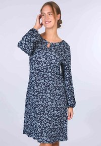 Marineblaue Kleid mit langen, ballonförmigen Ärmeln; hat ein florales Muster in Hellblau und eine kleine Schlüssellochöffnung am Ausschnitt.