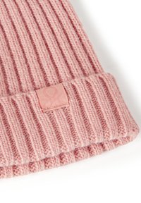Gorro de punto acanalado rosa con vueltas. Presenta una pequeña etiqueta de tela texturizada en un tono rosa a juego. Textura suave similar a la lana.