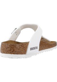 Infradito bianchi con footbed in sughero, suola in gomma e design minimalista. Presenta un cinturino a strappo e un logo del marchio ben visibile.