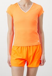 Kirkastava oranssi urheiluasu, jossa on V-mallinen lyhythihainen paita ja löysät shortsit, valmistettu sileästä, joustavasta kankaasta, jossa on valkoisia yksityiskohtia.