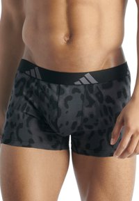 Boxerské šortky s potiskem černého leoparda, černý elastický pás se třemi šedými pruhy. Vyrobeno z hladkého, elastického materiálu.