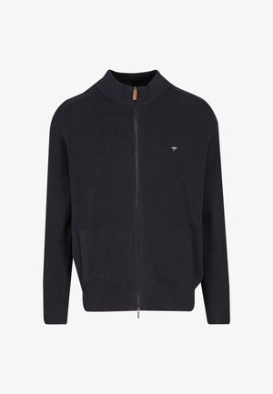 Marineblauwe geribbelde vest met rits en hoge kraag, twee zijzakken en een klein logo op de borst. Heeft een soepele textuur en elastische manchetten.