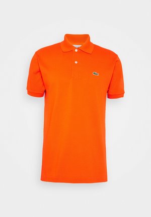 Hellorangefarbener Poloshirt mit kurzen Ärmeln, zwei weißen Knöpfen und kleinem grünem Krokodil-Logo auf der linken Brust.