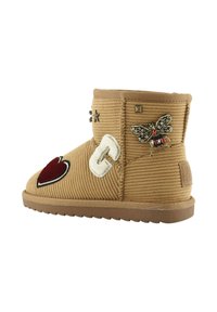 Stivale alla caviglia in corduroy color ocra con cuore rosso e decorazioni a forma di ape, caratterizzato da una superficie testurizzata, suola piatta e dettagli a motivo bianco in contrasto.
