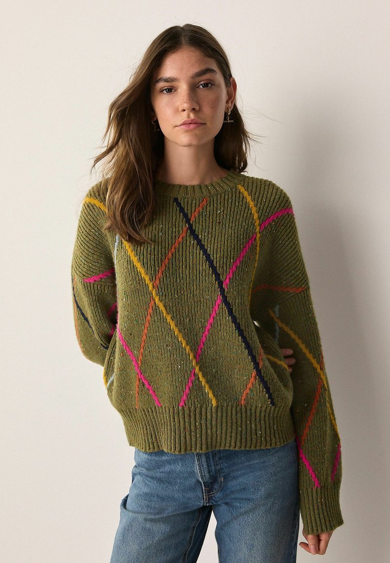 Green knitted sweater with multicolored diagonal patterns in pink, yellow, and navy. Features a ribbed neckline and cuffs. Casual fit.