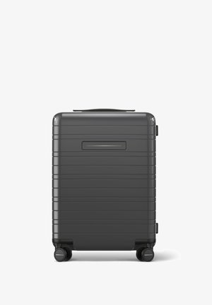 Gray hard-shell suitcase with horizontal grooves, a top handle, and four spinner wheels for easy maneuverability. Features a side ID slot.