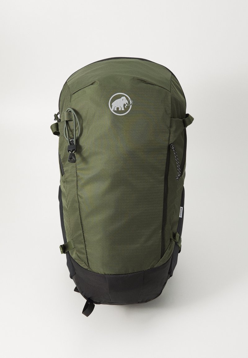 Zaino verde oliva con superficie testurizzata, presenta un logo, una cerniera superiore e un fondo nero. Tasche laterali con cinghie regolabili.
