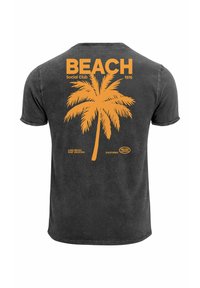 Black short-sleeve cotton T-shirt featuring a large orange palm tree graphic and the text "BEACH Social Club 1976" on the back.