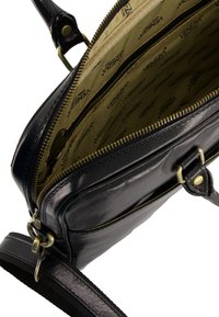 Schwarze Lederhandtasche mit goldfarbenen Beschlägen, ausgestattet mit einem Reißverschluss, mehreren Innenfächern und einem strukturierten Tragen. Innen mit markiertem Stoff ausgekleidet.