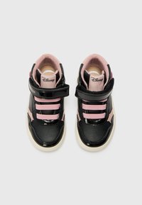 Ténis pretos e cor-de-rosa com um acabamento em verniz, apresentando três correias elásticas cor-de-rosa, uma correia de velcro e uma sola de borracha. Logótipo da Disney visível.