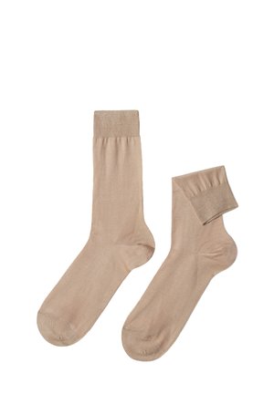 Beige bomuldsstrømper med ribbet top og glat tekstur, der har et klassisk design til knæhøjde for behagelig slid.