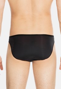Black swim briefs with a smooth texture and minimal coverage, featuring a slim waistband and seamless design, shown from the back.