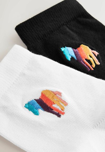 Calcetines en blanco y negro con un logotipo bordado de animal colorido que presenta franjas azules, moradas, rojas, naranjas y amarillas en cada par.