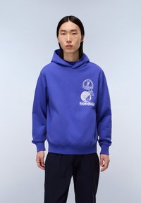 Felpa con cappuccio blu, dotata di tasca frontale, polsini a coste e toppe decorative. Realizzata in un tessuto morbido con un fit leggermente largo.