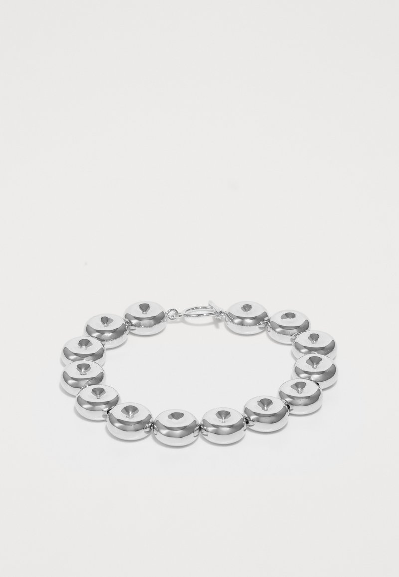 Bracciale d'argento con maglie metalliche rotonde e lucide, dotato di un'intaglio centrale, chiuso con un gancio, esposto su uno sfondo bianco.