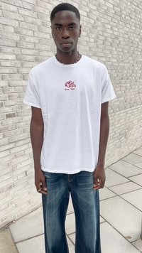T-shirt bianco in cotone con una piccola grafica rossa "Easy Tiger" sul petto. Jeans in denim blue ampi con una finitura sbiadita e design a gamba dritta.