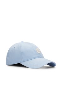 Lys blå bomull baseballcap med buet skygge og en brodert hvit logo foran. Har en justerbar stropp bak.