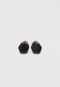 Μπλε σουέντ μοκασίνια με επίπεδη ταμπά σόλα, διαθέτουν κομμένο πίσω μέρος και ομαλή υφή. Απλά αλλά λειτουργικά.