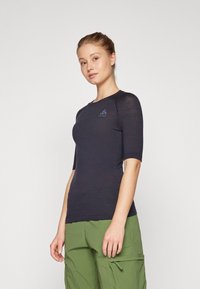 Dark blue, fitted short-sleeve athletic shirt with textured fabric and a round neckline. Features a logo detail on the chest.