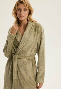Zielony szlafrok kąpielowy z miękkiej tkaniny rodzaju frotte, ozdobiony teksturowanym wzorem liści, z kołnierzem szalowym, długimi rękawami i zawiązywanym paskiem w talii.