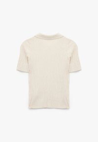 Crème poloshirt met korte mouwen, gemaakt van ribbelstof, met een subtiel textuurpatroon en een getailleerde pasvorm.