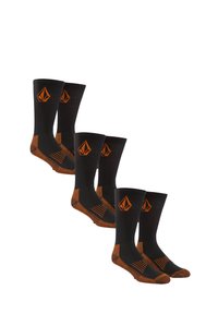 Chaussettes noires avec des accents orange, texture côtelée et un logo en forme de diamant. Conçues avec un talon et un orteil renforcés pour la durabilité.