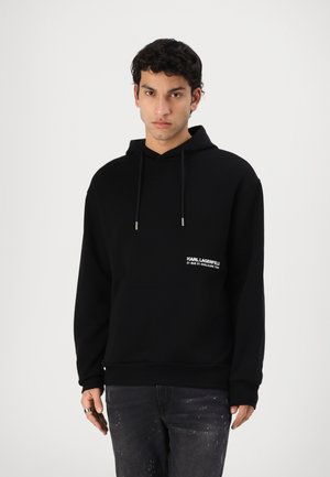 Felpa nera con cappuccio, dotata di tasca frontale, cappuccio con coulisse e logo bianco sul lato sinistro del petto. Realizzata in tessuto morbido, vestibilità comoda.