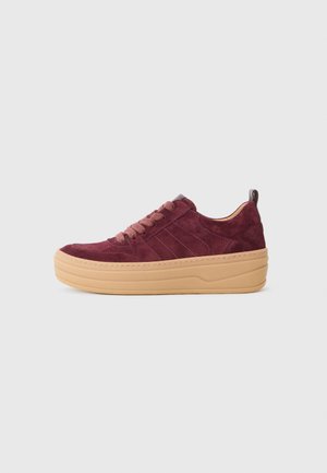 Burgundy suede sneakers with a light tan platform sole, round toe, and matching laces. Features three vertical stripes on the sides.