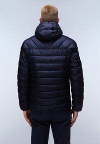 Chaqueta acolchada azul marino con capucha, que presenta un diseño acolchado, costuras verticales y puños elásticos. Textura de tela suave y brillante.