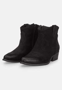 Botines de ante negros con un bajo tacón apilado, punta afilada, costuras decorativas y cremalleras laterales para facilitar su uso.