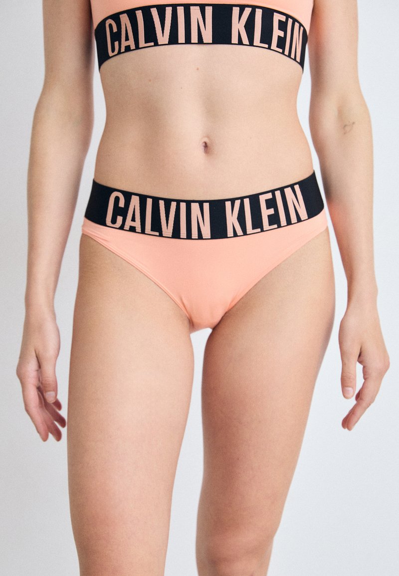 Calvin Klein bikini-set in zachte perzikkleurige stof. Voorzien van een zwarte elastische tailleband met gedurfde lettering. Eenvoudig ontwerp, aansluitende pasvorm.