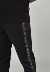 SIKSILK Tracksuit bottoms - black