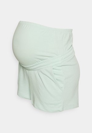 Lichtgroene zwangerschapsshorts met elastische tailleband en geplooid voorpand, ontworpen om een zwangere buik te accommoderen.