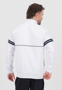Witte sweatshirt met een hoge kraag, marineblauwe horizontale strepen op de mouwen en een rechte achterkant. Gemaakt van een glad, rekbaar materiaal.
