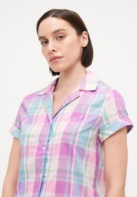 Ελαφρύ, παστέλ πουκάμισο με καρό σχέδιο, κοντά μανίκια, κουμπιά στο μπροστινό μέρος, τσέπη με λογότυπο και γιακά από σατέν υφή.