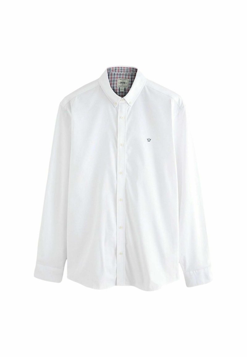 Chemise blanche à manches longues en coton, dotée d'un col et d'un petit emblème brodé. Intérieur doublé d'un motif à carreaux.
