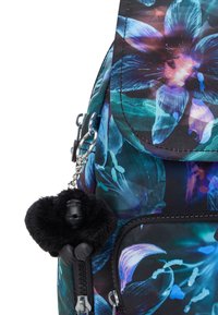 Zaino in tessuto nero con motivo floreale in tonalità blu e viola; presenta un portachiavi a forma di gorilla peloso nero su un gancio di metallo argentato.