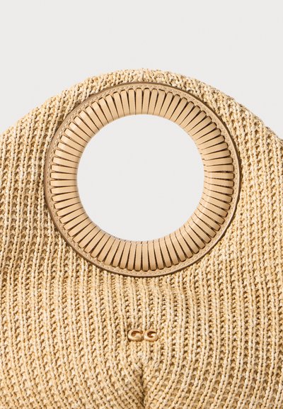 Woven straw handbag with a circular wooden handle, featuring a textured cream surface and a gold logo accent on the front.