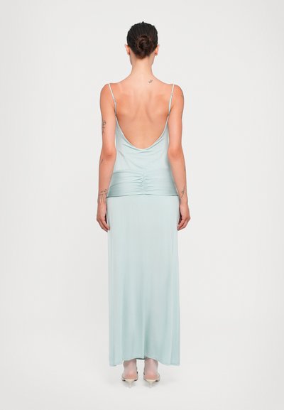 Lichtblauw, mouwloze maxi-jurk met een lage rug. Kenmerkt zich door geplooide details bij de taille en een soepele, vloeiende stoftextuur.