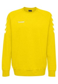 Geel sweatshirt met een ronde hals, geribbelde manchetten en onderrand, met een witte Hummel-logo en contrasterende witte chevronstrepen op de mouwen.