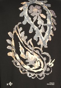 Tessuto nero con un grande e intricato design paisley in tonalità beige e grigie. Testo "DEPARTIMENTO CREATIVO" è in basso.