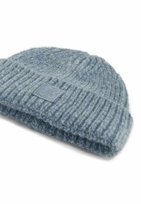 Light blue knit beanie hat with a ribbed texture and a fold-up cuff. Features a small, square tag with a design stitched on the side.