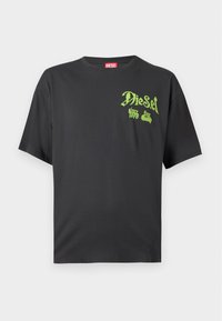 Μαύρο κοντομάνικο t-shirt Diesel με πράσινο λογότυπο και κείμενο "Diesel since 1978" στην πάνω αριστερή πλευρά του στήθους και μια κόκκινη ετικέτα στον λαιμό.