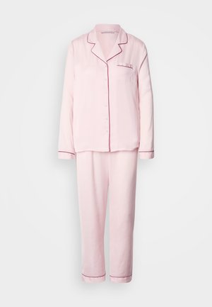 Roze pyjamaset gemaakt van zachte stof, met een bovenstuk met knopen, kraag, zak en contrasterende biezen; bijpassende broek met elastische tailleband.